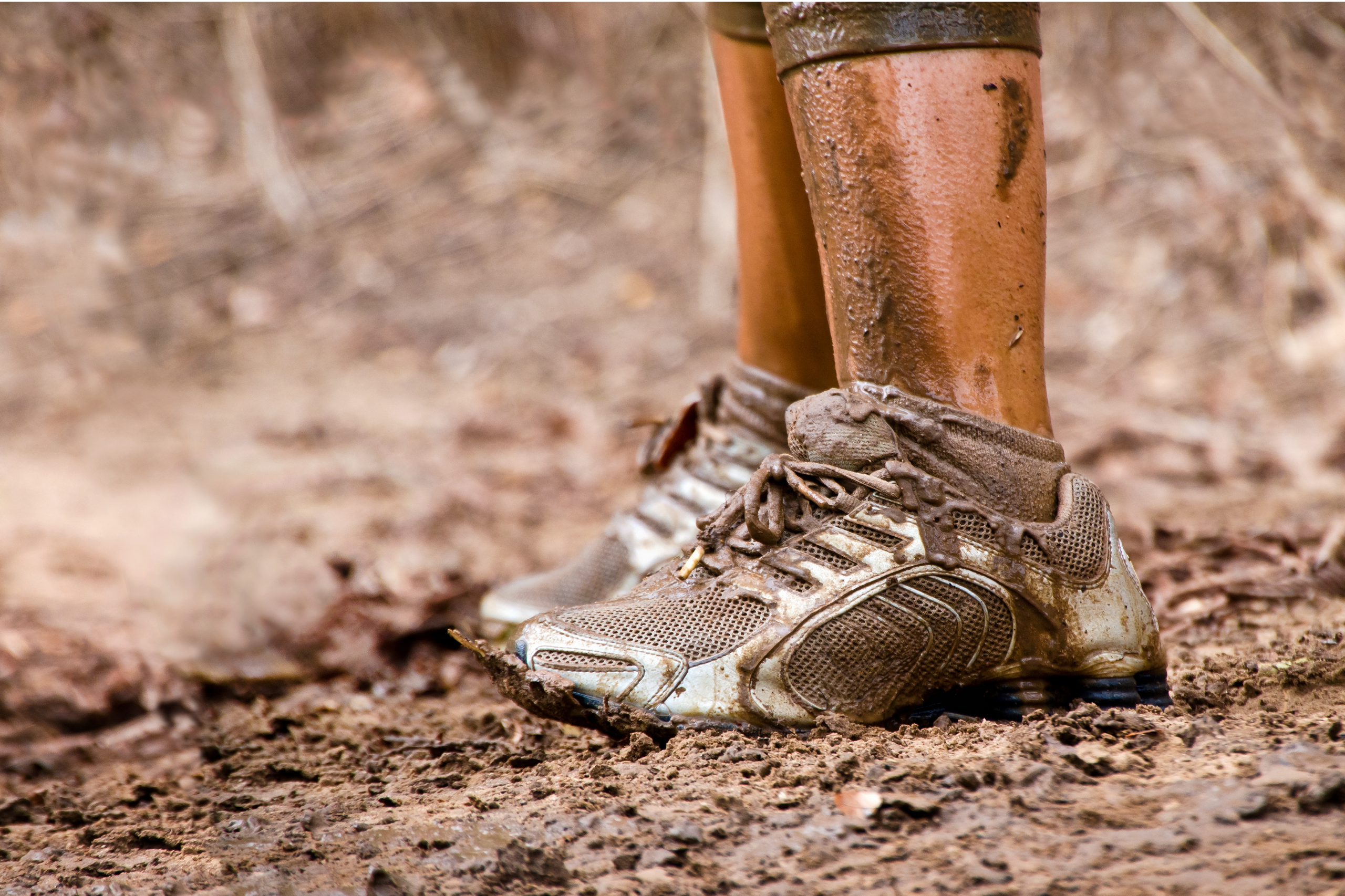 white sneakers on a dirty trail